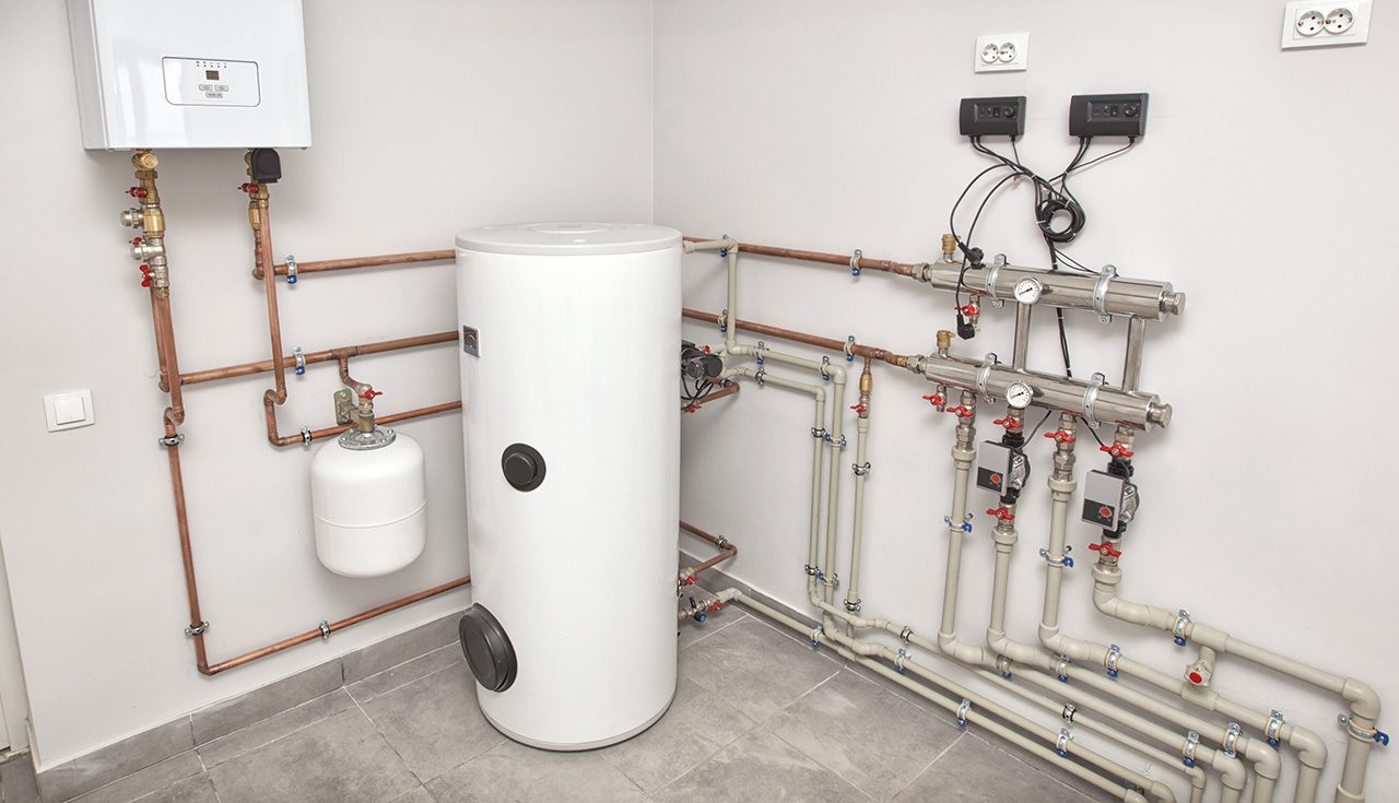 A neatly organized indoor plumbing setup with copper pipes, valves, and a white cylindrical tank, mounted on tiled walls.