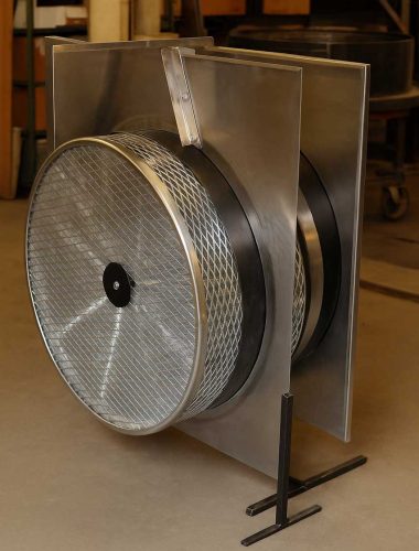 A detailed view of a ventilation system with a circular fan and protective metal casing, highlighting its sturdy construction.